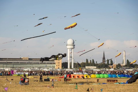 Flying kite in the shape of Batman in front of the tower at the kite festival on Tempelhofer Feld