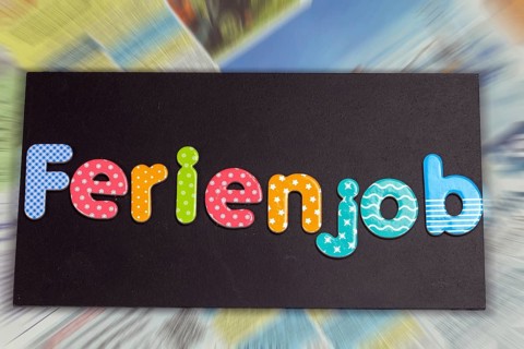 Symbolic image of a holiday job: board with the inscription FERIENJOB in front of the job adverts