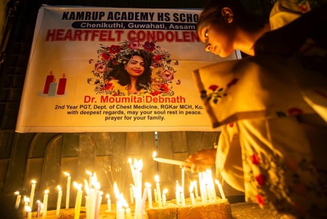Students light candles as they pay tribute to a victim of rape and murder of a doctor inside a
