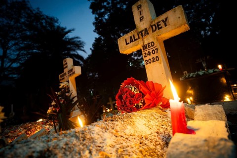 People from Christian community light candles and offer prayers on the grave of their relative