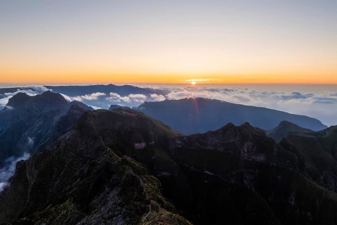Aerial drone view of mountains over clouds near Pico Ruivo on sunset. Madeira island, Portugal,