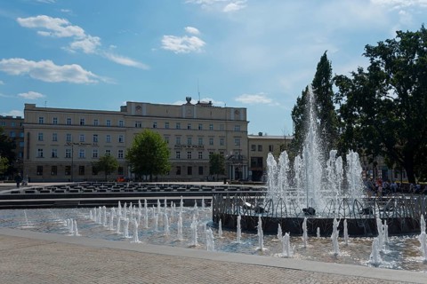 Lively public square with impressive fountain and surrounding buildings, fountain, post office,