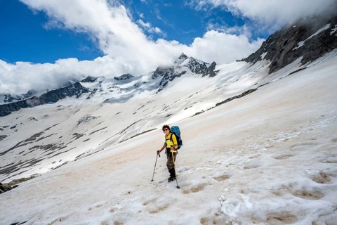 Mountaineer in a snowfield, descent from the summit of Schönbichler Horn, view of snow-covered and