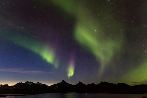 Northern Lights, Aurora borealis over a fjord with steep mountains, autumn, Tasiilaq, East