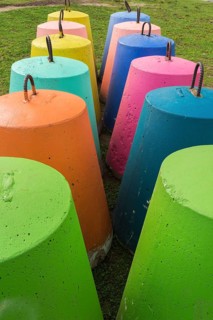 Two rows of fluorescent green, orange, blue, pink, turquoise and yellow painted bell shaped