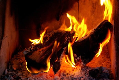 Burning wood in the fireplace with bright flames and embers that radiate warmth, Sweden, Europe