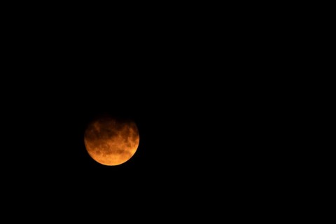 Full super moon red orange in colour in the night sky, Suffolk, England, United Kingdom, Europe