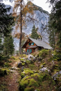 A hut in the mountains of the Gosaukamm. A path and rocks with moss. In the background a part of
