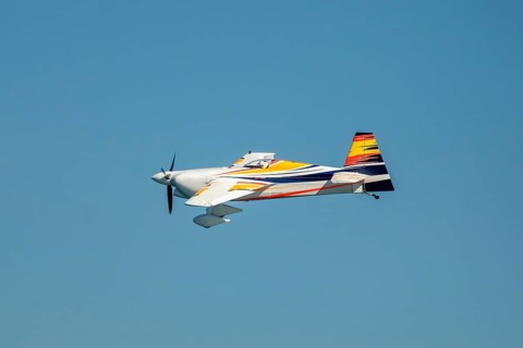 Stunt aerobatic plane performing stunts in blue sky. Concept of speed, difficulty, precision, risk,