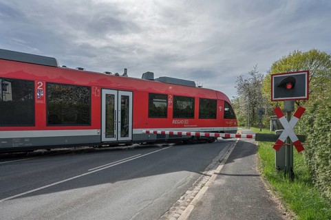 A regional train crosses a level crossing with a barrier, Schnaittach, Middle Franconia, Bavaria,