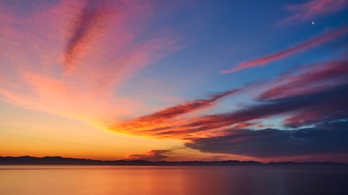 Colourful sky with crescent moon at sunrise over the sea, Mani Peninsula, Peloponnese, Greece,