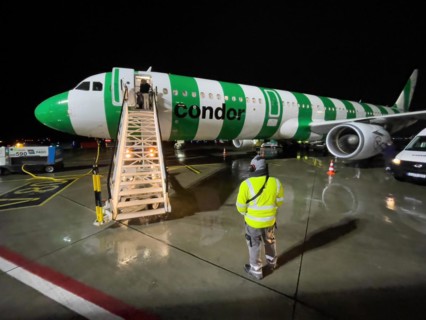 Night shot of Condor aircraft plane Airbus A321 standing landed in parking position on apron apron