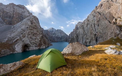 Wild camping, camping in the wilderness with a tent in front of mountain lake Kol Suu, Sary Beles