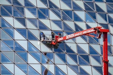 Building cleaners cleaning window panes, cleaning a facade, lorry working platform of the German
