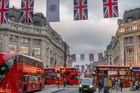 Red double-decker buses, English flags, evening mood, Oxford Circus, London, London region,