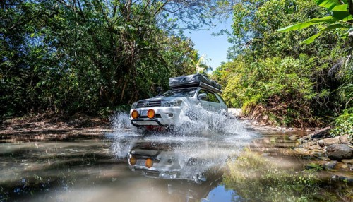 4x4 car drives through a river, water crossing with the off-road car, Costa Rica, Central America