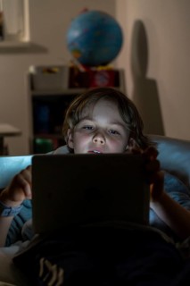 A boy plays computer games on a tablet PC