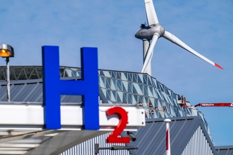 Hydrogen filling station in Antwerp, for cars and lorries, H2 lettering, wind turbine in the