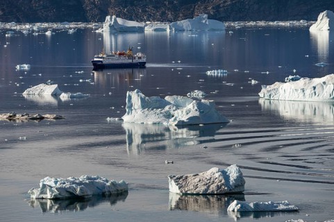 Expedition cruise ship between icebergs, Scoresbysund or Kangertittivaq in Greenlandic, the largest
