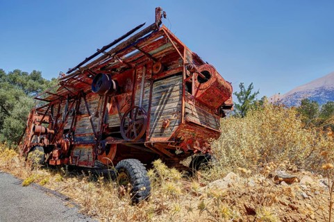 Rusty combine harvester in rural area on a road in summer weather, wrecked vehicle, Crete, Greek