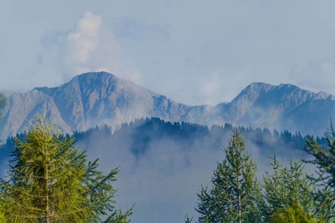 Karawanken, mountains in Slovenia in the background with clouds and fog in the foreground with