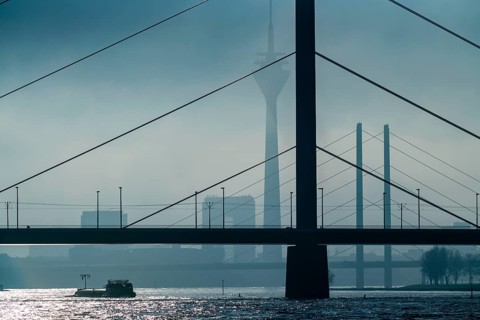Dense fog slowly lifting, cargo ships on the Rhine near Düsseldorf, in front the Oberkassler