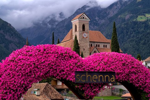Photopoint, sign, flower heart, heart made of flowers, behind it the new parish church Maria