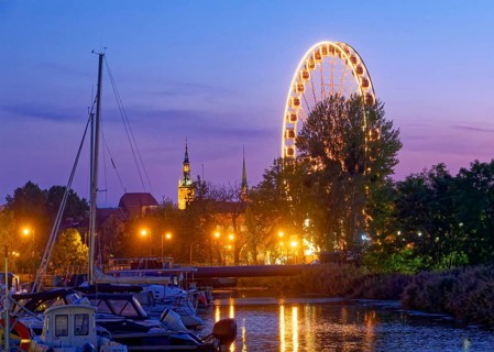The Ferris wheel illuminated in the evening on the Motlawa, Motlawa, in the harbour district of
