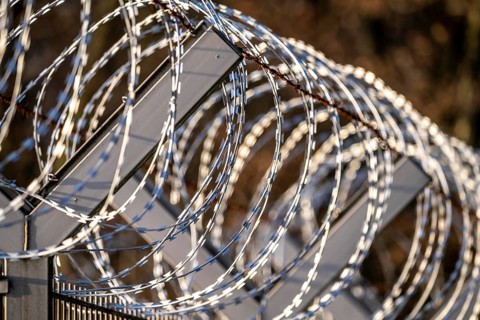 Symbolic image security, S-wire rolls, NATO wire, on a fence top, demarcation of a property,