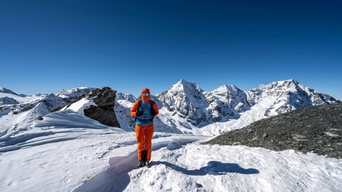 Ski tourer on foot at the summit of the Madritschspitze, mountain panorama with snow-covered