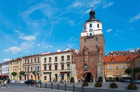 Historic Old Town with an impressive brick tower under a clear blue sky, Krakow Gate, Brama