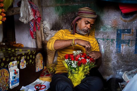 Vendor makes rose bouquet to sell in a street flower shop, on the occasion of Valentines day on