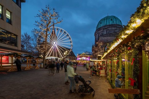 Ferris wheel at the winter village, Christmas market at dusk, St Elisabeth's Church on the right,