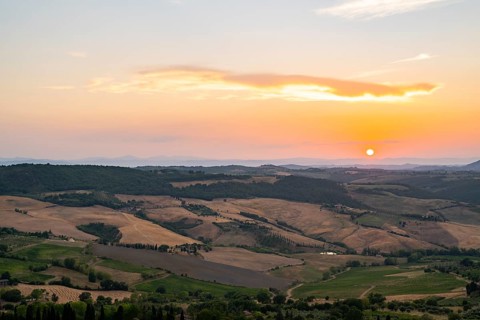 View from Montepulciano into a typical Tuscan landscape in Val d'Orcia with hills, trees, fields,