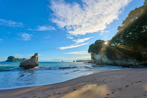 Sandy beach beach with waves and sunlit rocks, tranquillity and natural beauty, Cathedral Cove,