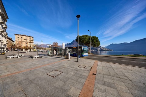 Bus stop, public bus, hilly landscape, blue sky with veil clouds, Lake Lugano, street Riva Vincenzo