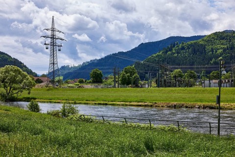 River Kinzig, bank with meadow and trees, electricity pylon, transformer station, hilly landscape
