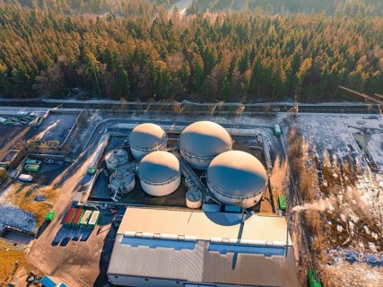 Aerial view of an industrial tank farm surrounded by snow-covered forest, Neubulach, Black Forest,