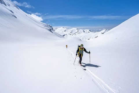 Two ski tourers in a mountain landscape with snow, behind summit Mittaghorn and Wildhorn, ascent to