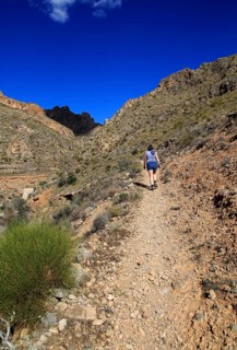 Woman walking Ruta del Agua to Huebro, Sierra Alhamilla mountains, Nijar, Almeria, Spain, Europe