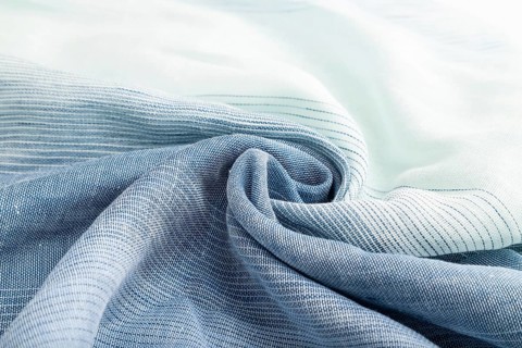 Fragment of blue linen tissue. Side view, natural textile background and texture. wave concept,
