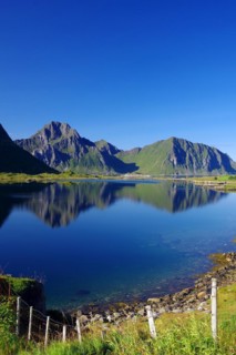 Mountains reflected in the calm waters of an inlet, Leknes, Vestvågøy, Lofoten, Nordland, Norway,