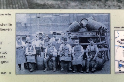Old information notice with historic photo of male men brewery workers, Halesworth, Suffolk,