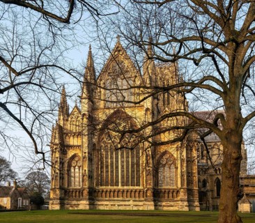 East frontage Lincoln cathedral church winter morning light viewed through tree branches, city of