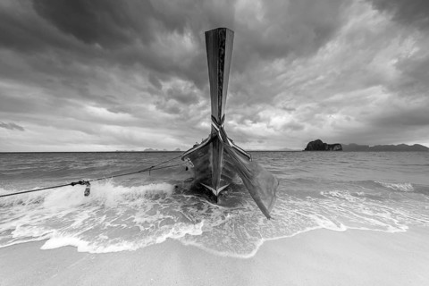 Longtail boat on the beach, dark rain clouds behind, Koh Ngai Island, Andaman Sea, Satun Province,