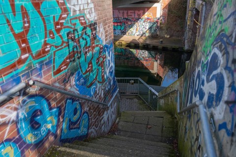 Stairs under the city railway bridge to the canal, graffiti, waterway, Linden harbour lock, Limmer,