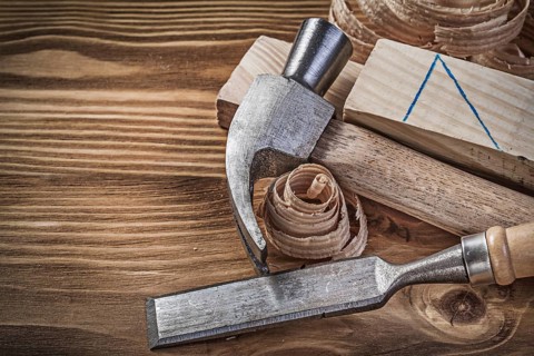 Claw hammer firmer chisel wooden studs shavings on vintage wood board