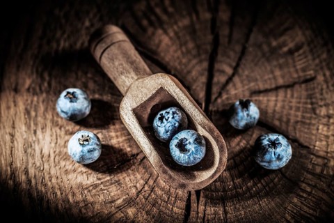 Bilberries in vintage spoon on grunge board