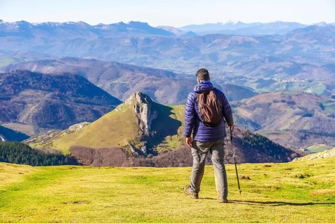 Male hiker enjoying the view of the mountains and valleys of the basque country while trekking
