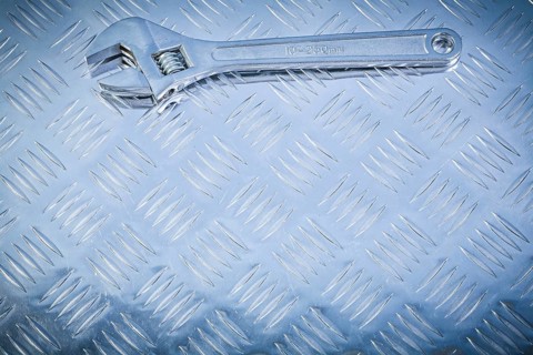 Adjustable tensioner on fluted metal background construction concept